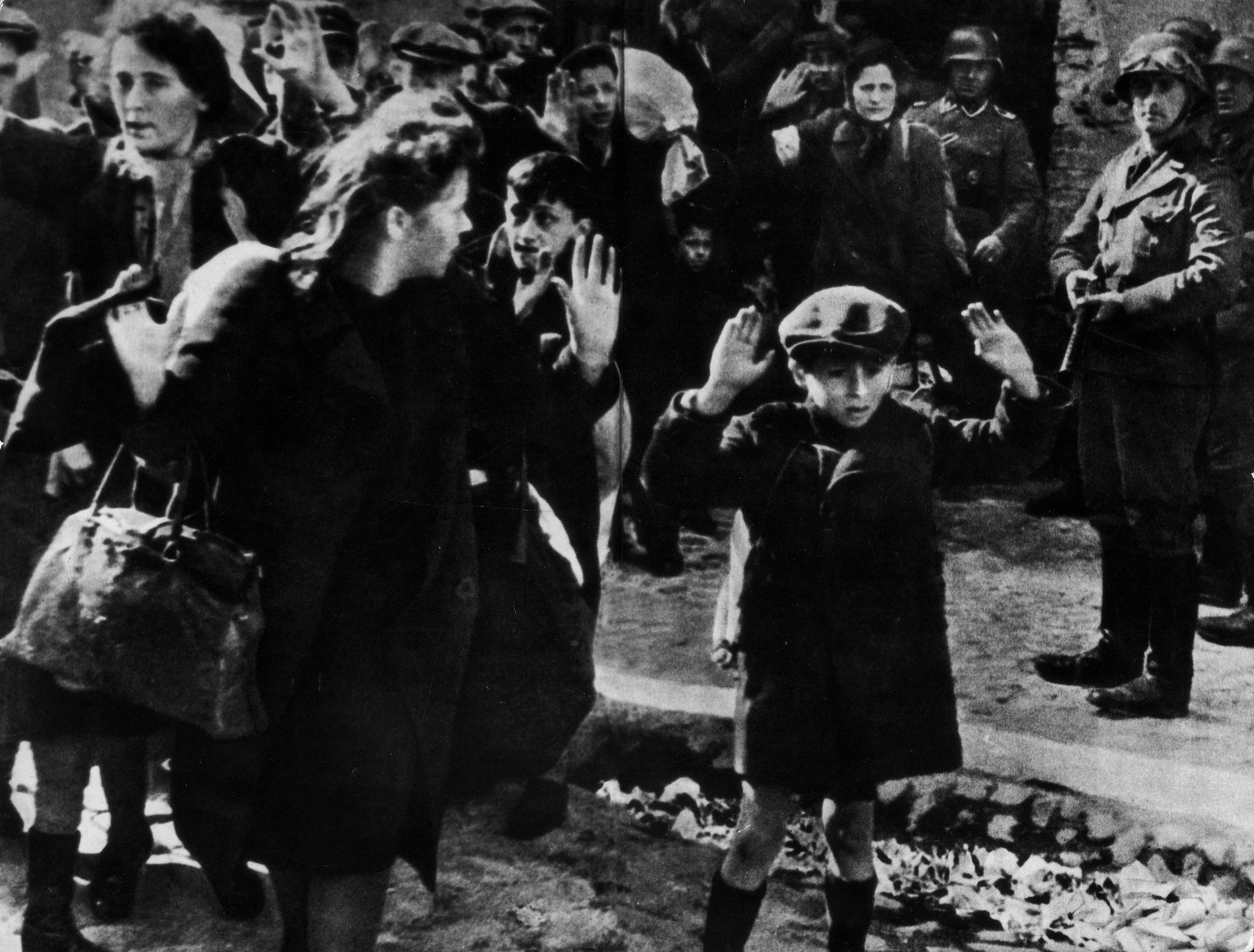 Esta fotografia de 1943, de um relatório oficial da SS, mostra civis judeus sob a mira de uma arma por tropas nazistas da SS depois de serem forçados a sair de um bunker onde estavam abrigados durante a Revolta do Gueto de Varsóvia. / Mondadori via Getty Images