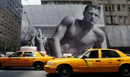 Cabs drive in front of a billboard surrounding the future ho