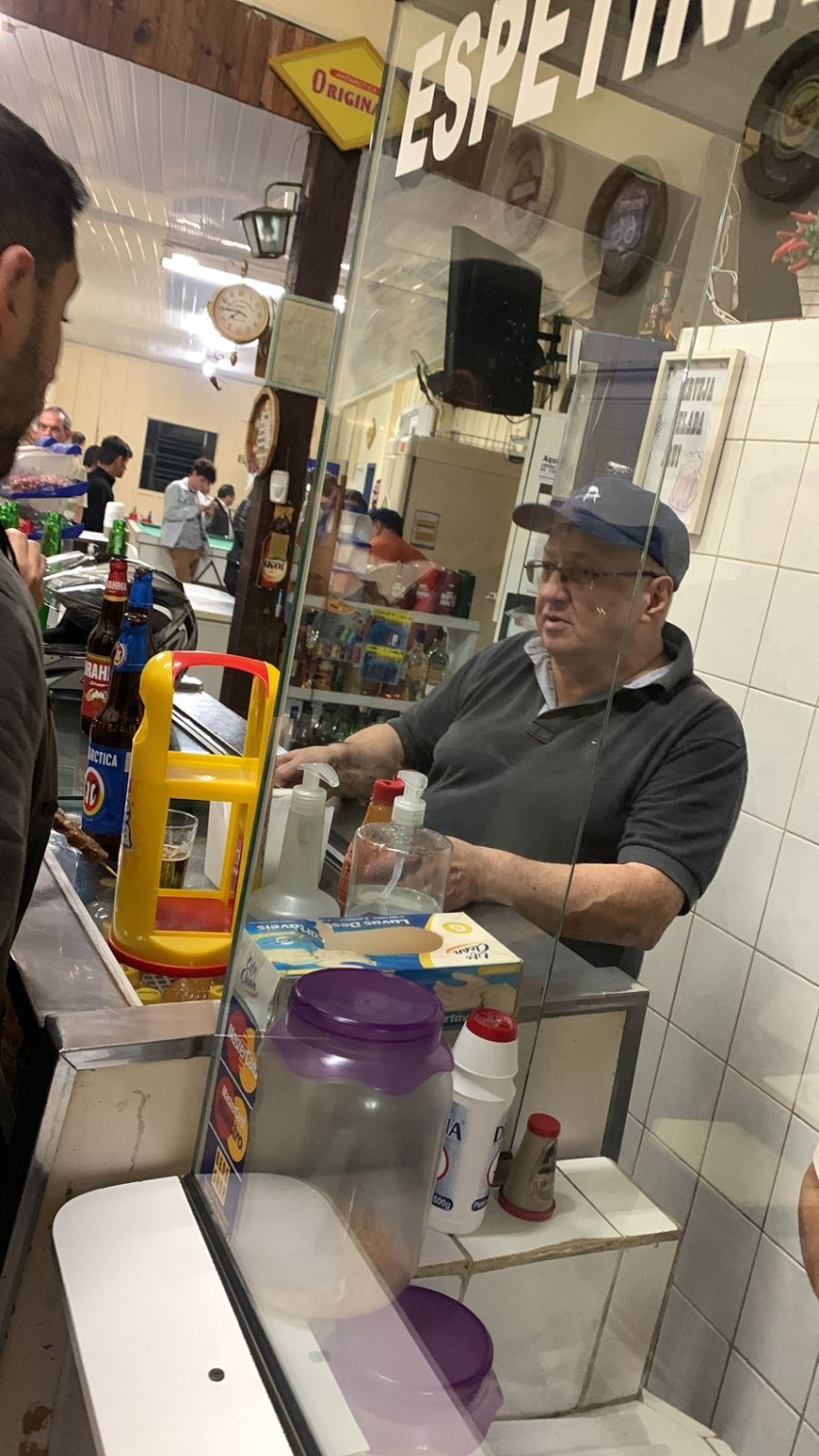 Dionísio atende clientes da Lanchonete Aquarius, em Curitiba, nesta quinta-feira (26), usando um boné da Jovem Dionísio. / Arquivo Pessoal