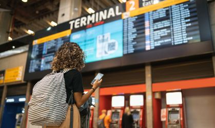 Tourist looking at arrivals and departures table