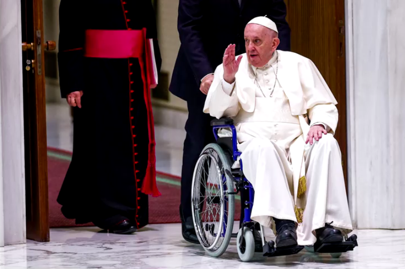 Papa usa cadeira de rodas em público pela primeira vez desde que voltou a sentir dores no joelho. • Reuters