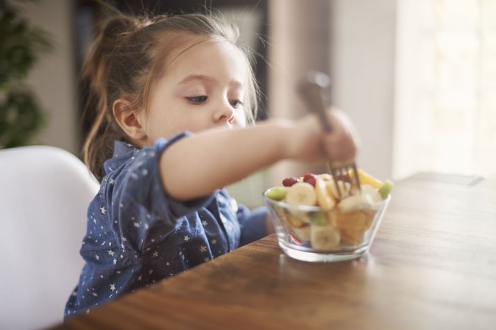 Criança comendo fruta / Anna Bizon / Freepik