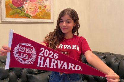A brasileira Sofia Santos de Oliveira com blusa e bandeira da Universidade de Harvard