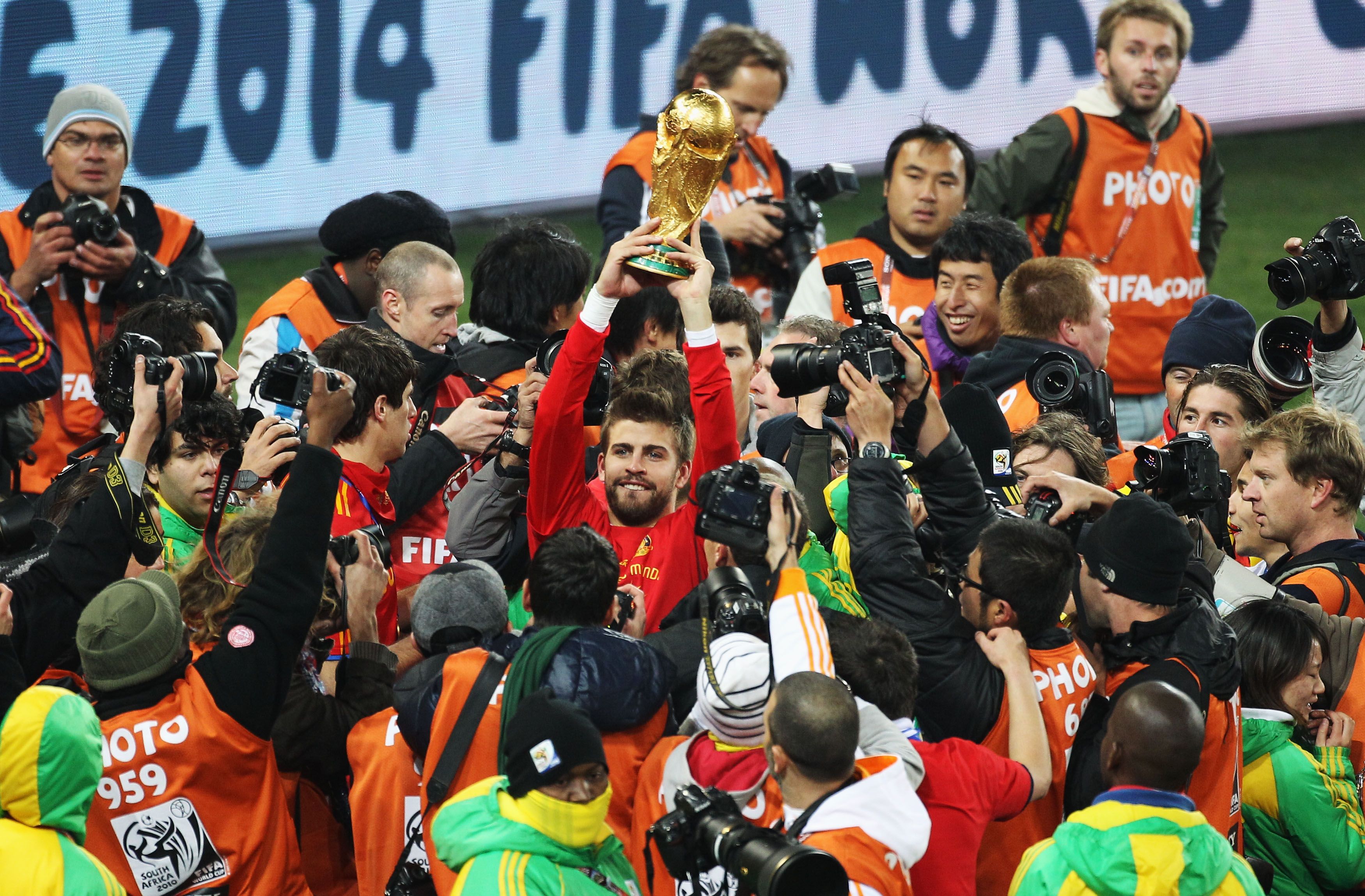 Gerard Piqué segura a taça da Copa do Mundo após vitória da Espanha na África do Sul, em 2010 / FIFA via Getty Images