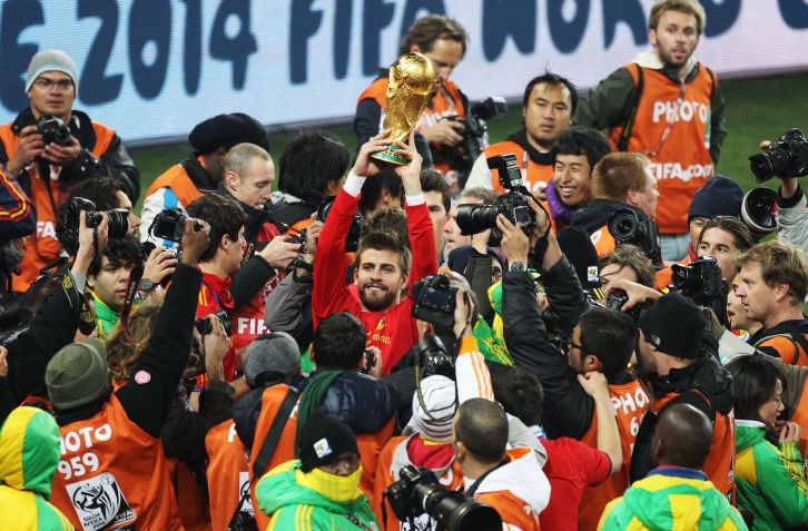 Gerard Piqué segura a taça da Copa do Mundo após vitória da Espanha na África do Sul, em 2010 / FIFA via Getty Images