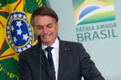 Presidente Jair Bolsonaro (PL) diante de painel com o logo do governo federal