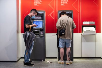 Clientes retiram dinheiro de um caixa eletrônico em Hong Kong