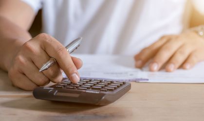 Young woman writing make note and doing calculate finance at home office.
