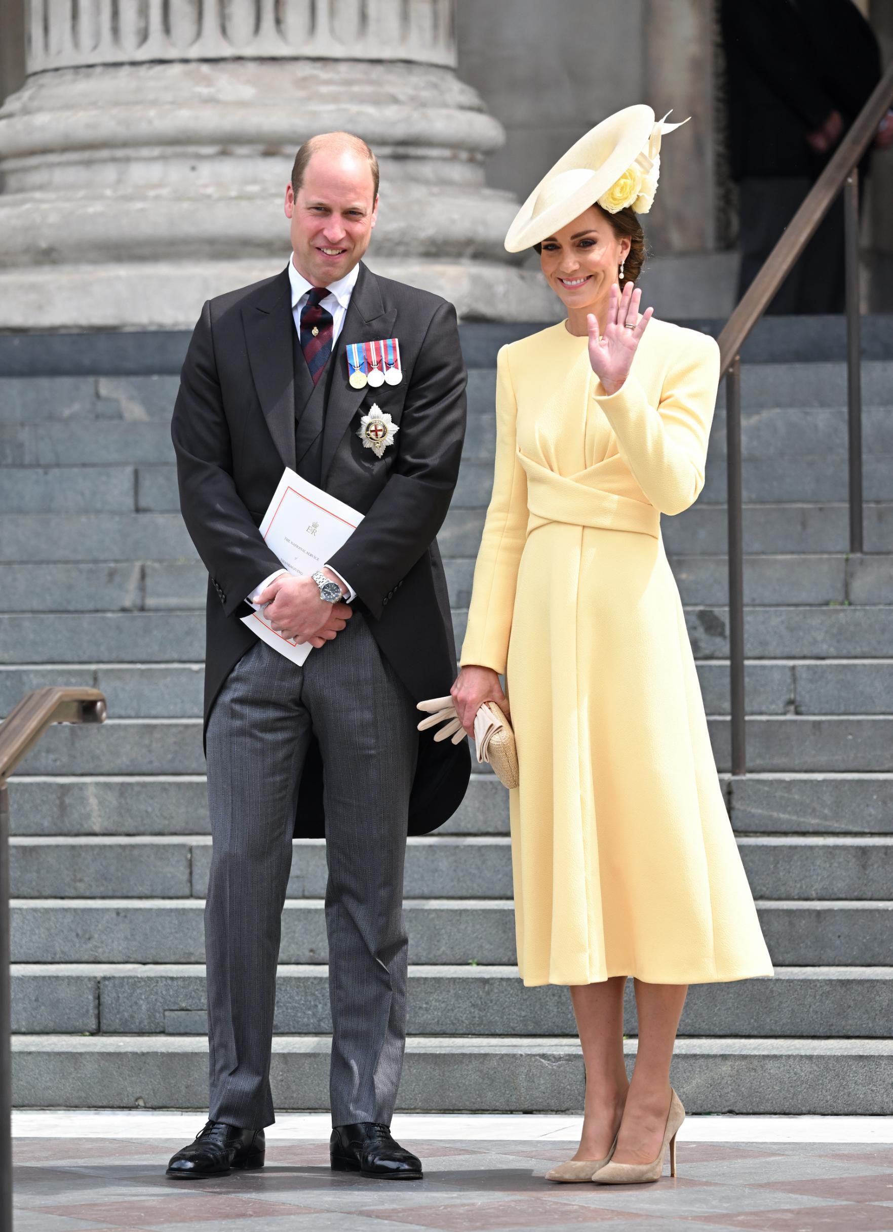 Kate Midleton usou um conjunto amarelo amanteigado, com um vestido longo combinado com um detalhe de cintura torcido e brincos de pérolas. Seu chapéu era facilmente um dos mais marcantes do dia, com flores amarelas sob a aba / Karwai Tang