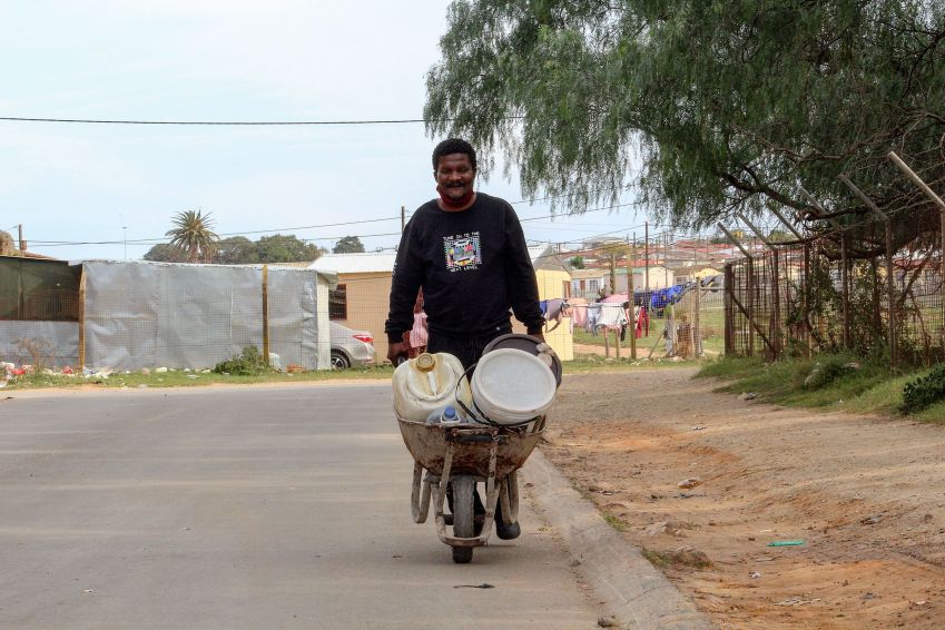 O sul-africano Morris Malambile diz que empurrar um carrinho de mão cheio de recipientes de água todos os dias é "cansativo" / Riaan Marais para CNN