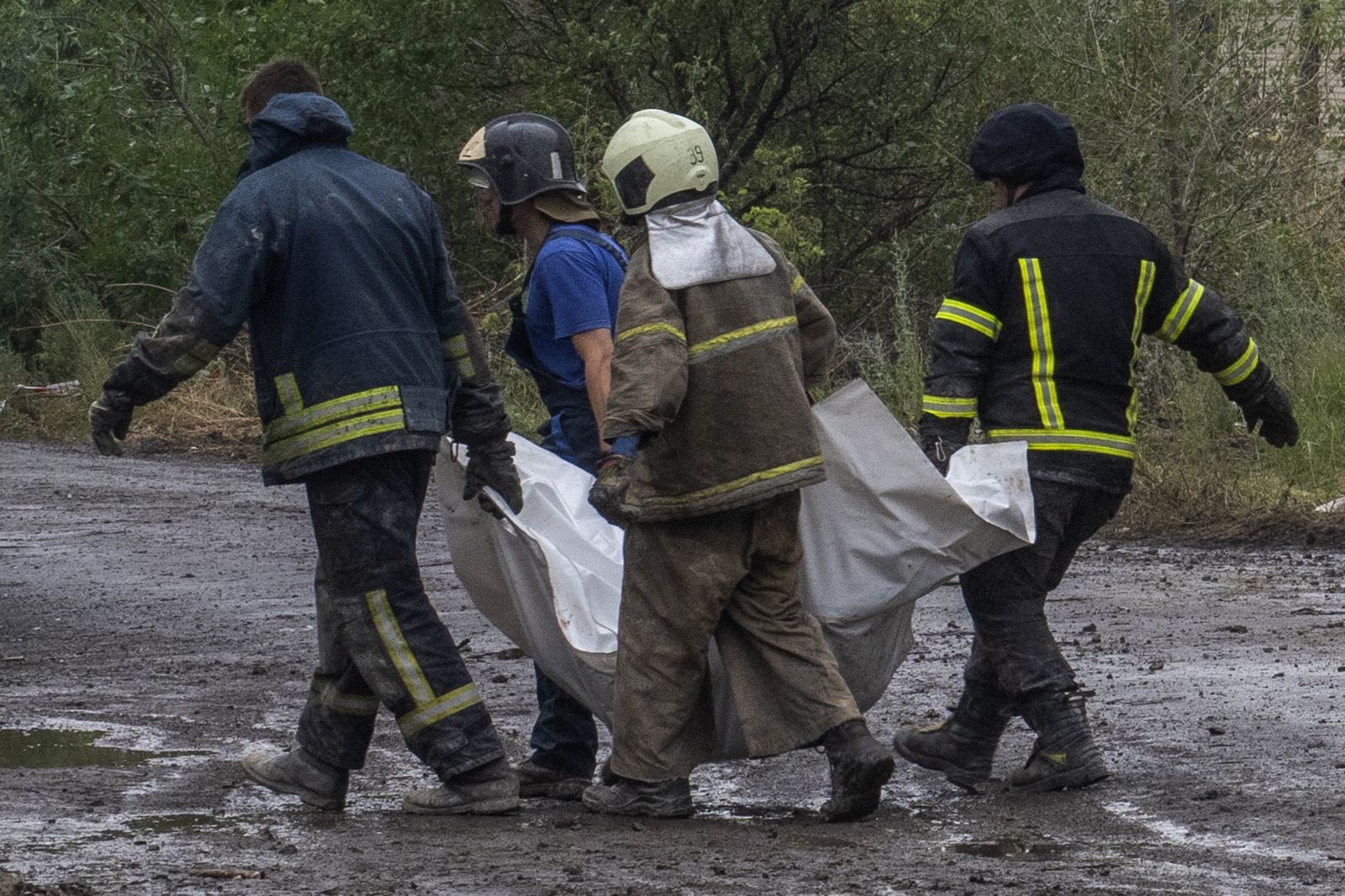 Equipes de emergência ucranianas carregam o corpo sem vida de uma vítima encontrada sob escombros em Chasiv Yar, região de Donetsk, leste da Ucrânia, em 11 de julho