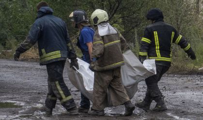 Equipes de emergência ucranianas carregam o corpo sem vida de uma vítima encontrada sob escombros em Chasiv Yar, região de Donetsk, leste da Ucrânia, em 11 de julho