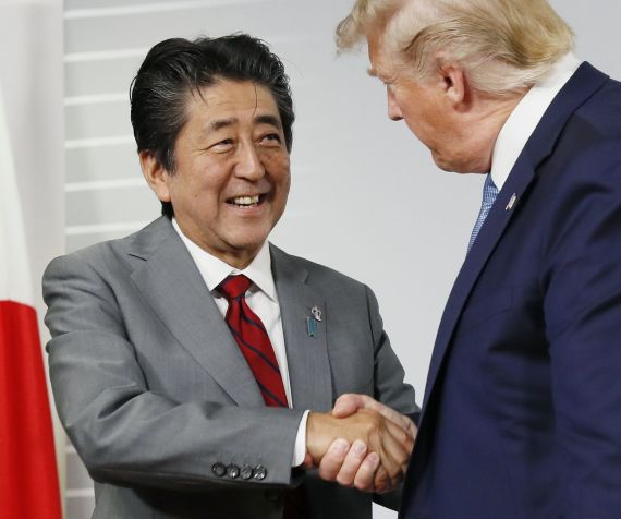 Primeiro-ministro Shinzo Abe cumprimenta Donald Trump em encontro bilateral do G7, em agosto de 2019, na França. / Kyodo News Stills via Getty Imag