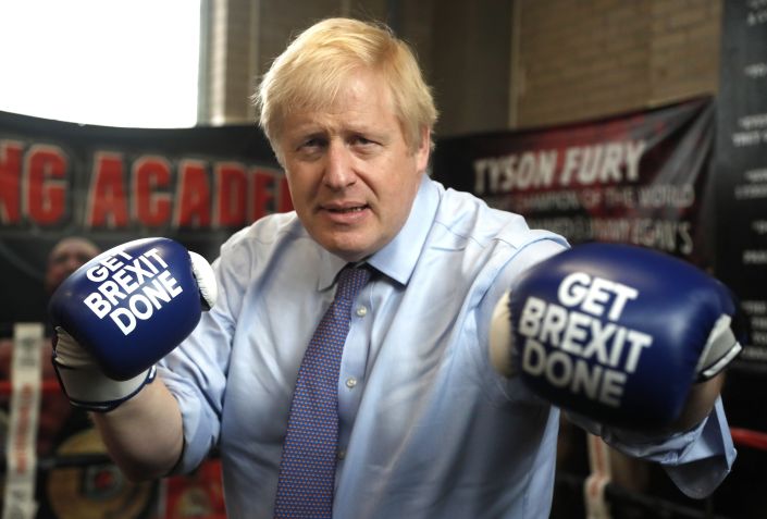 Boris Johnson posa para foto usando luvas de boxe com a estampa "Faça o Brexit" em novembro de 2019, em Manchester, na Inglaterra. / Frank Augstein - WPA Pool/Getty Images