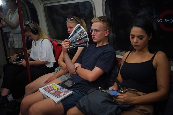 Um homem se abana com um jornal enquanto viaja na linha de metrô Bakerloo no centro de Londres durante a onda de calor. / Yui Mok/PA Images via Getty Images