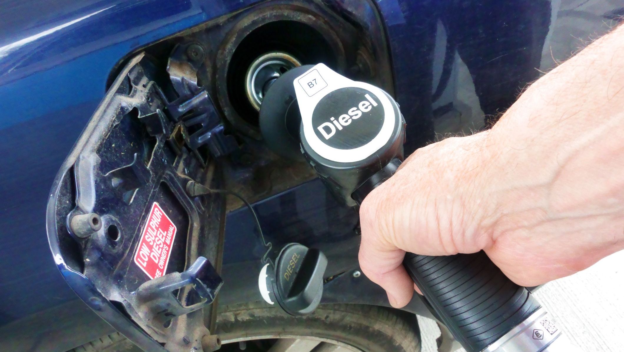 Pessoa abastece carro com bomba de diesel