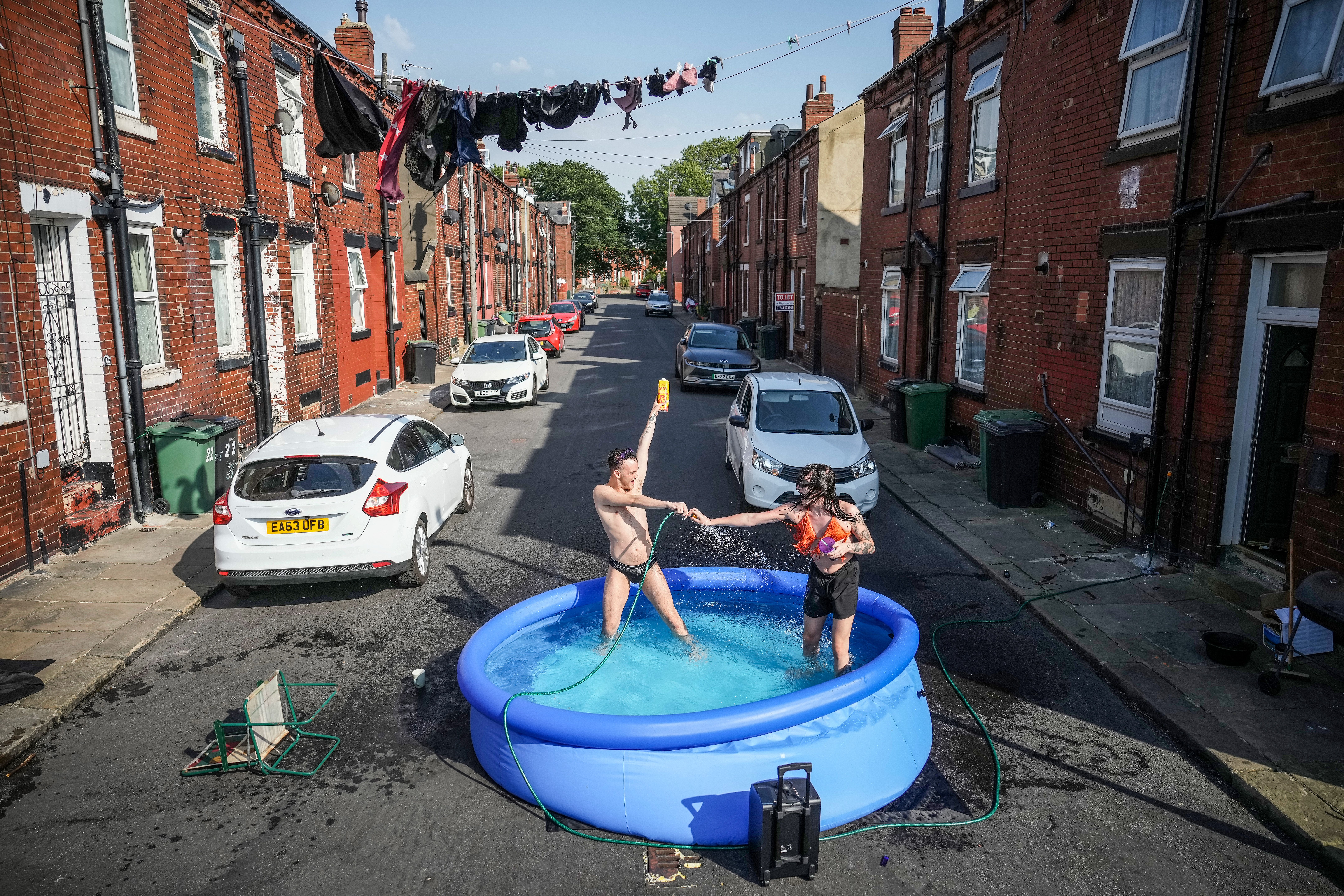 Moradores dão um mergulho em uma piscina para se refrescar do lado de fora de sua casa em 19 de julho de 2022 em Leeds, Reino Unido. / Getty Images