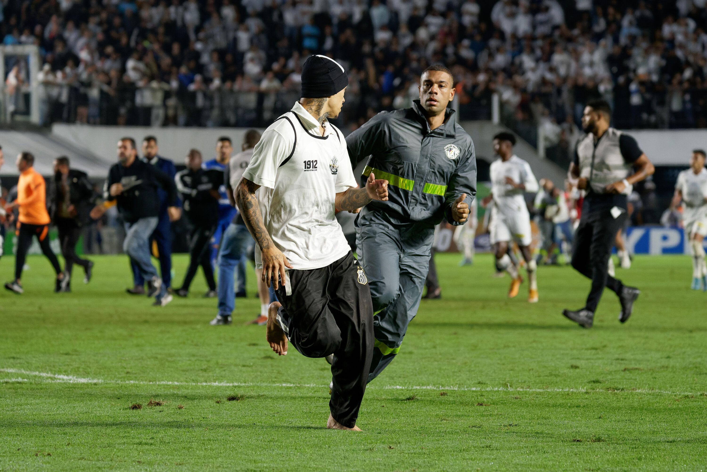 Torcedores do Santos invadem o campo na partida entre Santos e Corinthians pelas oitavas de final da Copa do Brasil. / ANDERSON ROMÃO/PHOTOPRESS/ESTADÃO CONTEÚDO