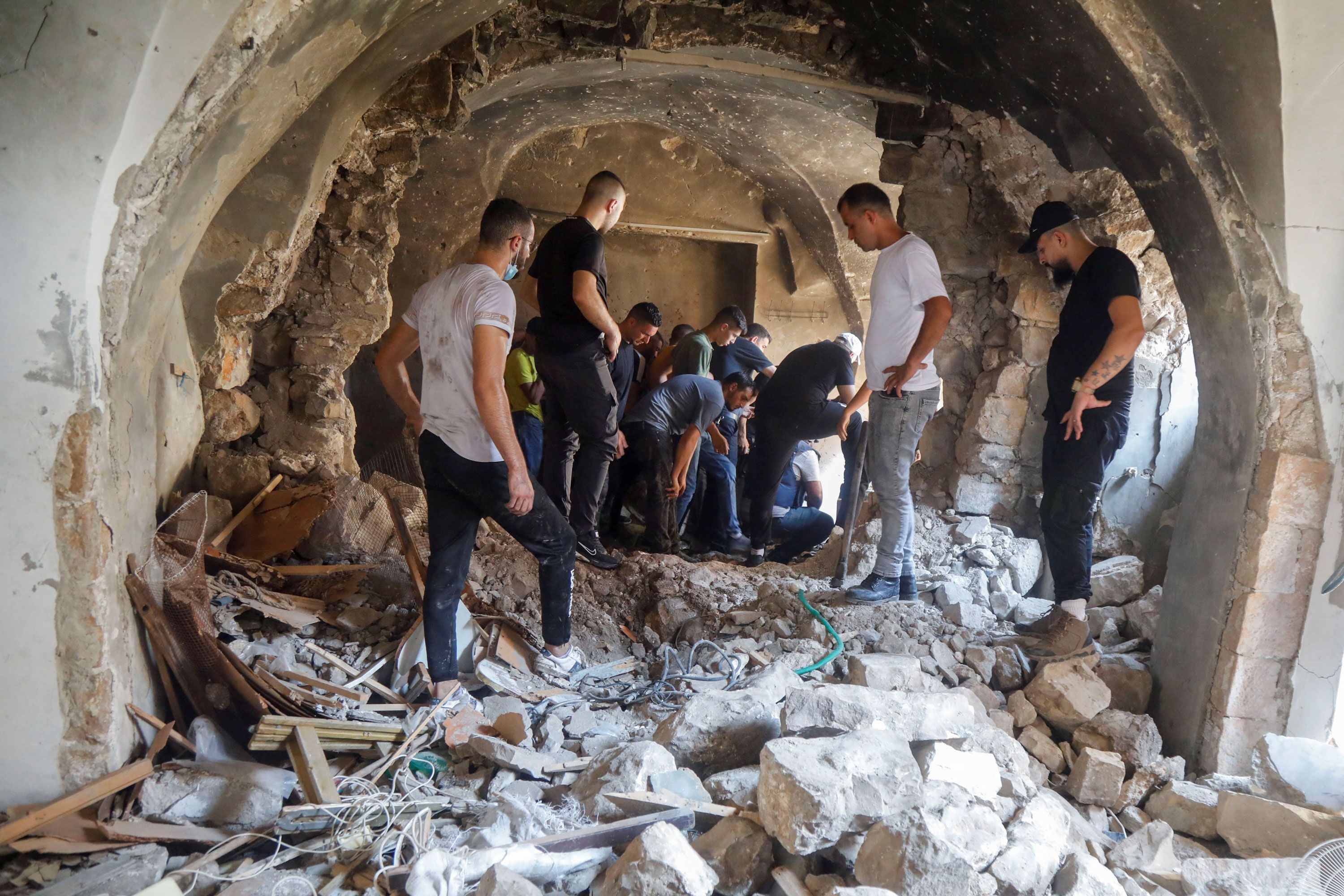 Palestinos inspecionam um prédio danificado durante uma operação militar israelense em Nablus