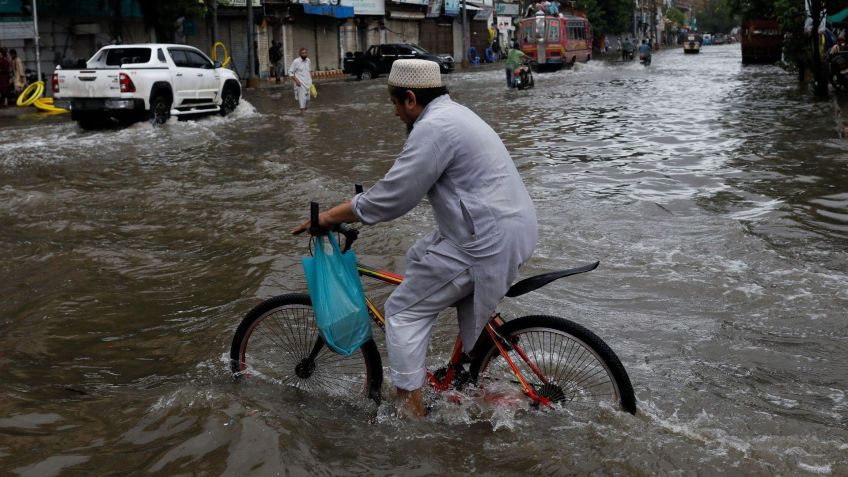 Um homem anda de bicicleta ao longo de uma estrada inundada, após fortes chuvas durante a estação de monções em Karachi, Paquistão / Akhtar Soomro/Reuters