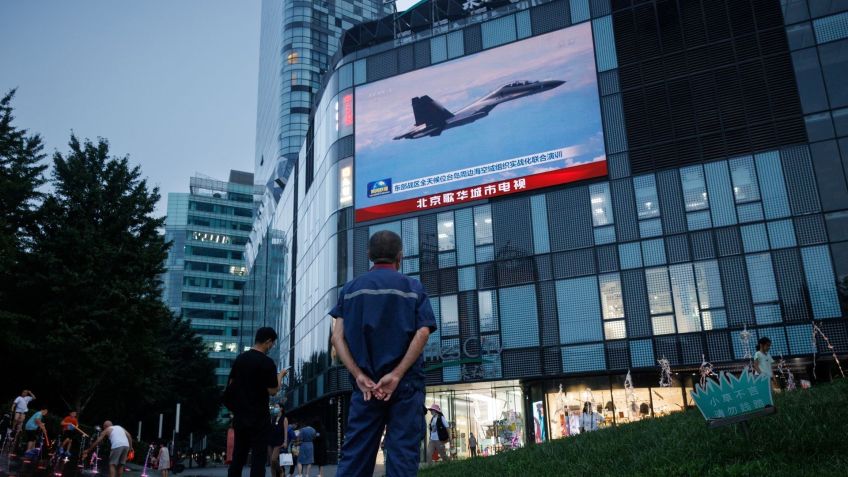 Homem em Pequim assiste a noticiário de CCTV, que mostra um jato de combate durante operações militares chinesas perto de Taiwan / Reuters