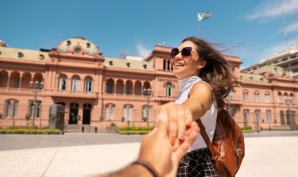 Couple holding hands in front of Casa Rosada in Buenos Aires