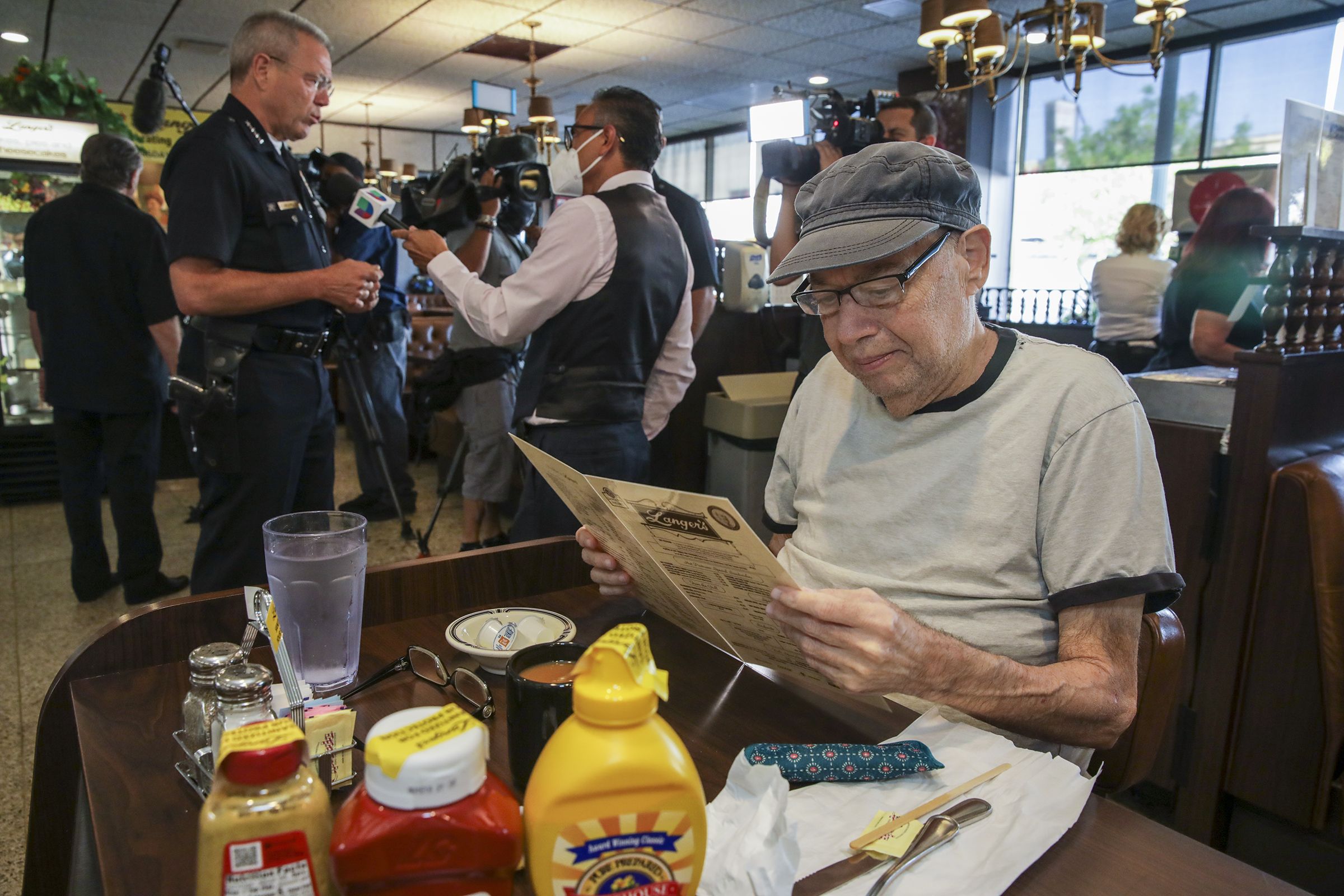 Cliente analisa cardápio físico em restaurante / Irfan Khan / Los Angeles Times via Getty Images