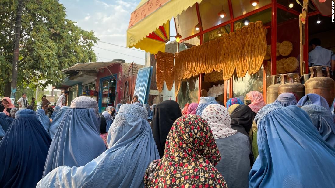 Mulheres se aglomeram do lado de fora de uma padaria em Cabul, no Afeganistão, esperando receber esmolas dos clientes / Brent Swails / CNN