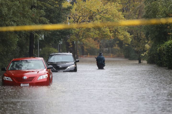 Pedestre caminha em uma rua inundada em Kentfield, Califórnia. Um rio atmosférico de categoria 5 levou fortes chuvas e ventos para a área da baía de São Francisco. / Foto: Justin Sullivan/Getty Images