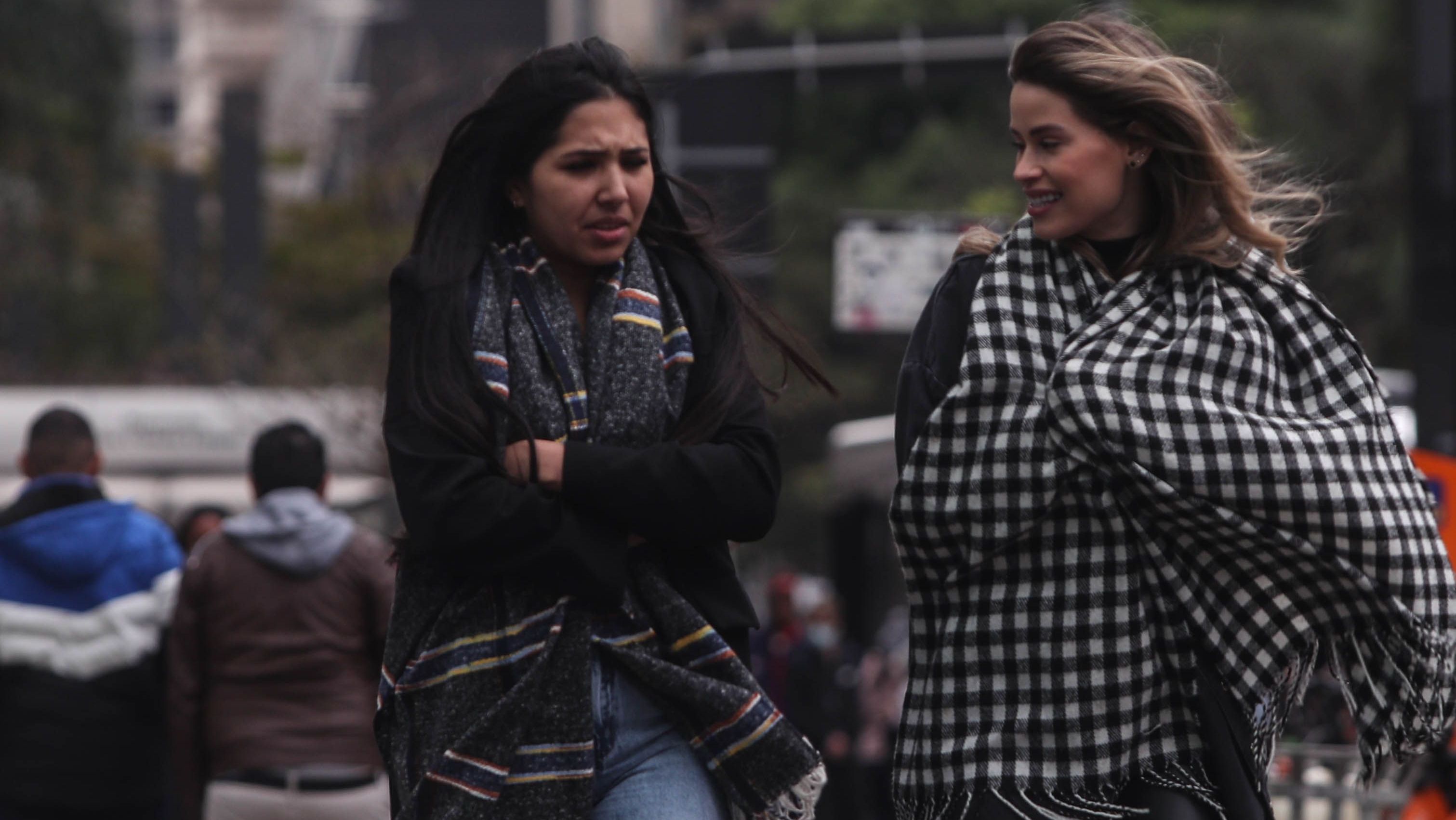 Mulheres agasalhadas e encolhidas com frio