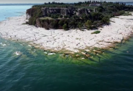 Seca faz surgir praia rochosa em lago na Itália