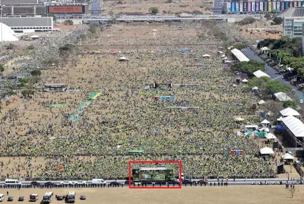 | Foto 2 – que o post diz ser de 2022. Na segunda imagem compartilhada no post, atribuída a 2022, também é possível ver o caminhão com o banner dos 200 anos e a estrutura para desfile [à direita]