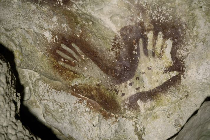 Estênceis de mão foram encontrados na caverna onde o esqueleto amputado foi descoberto. / Kinez Riza