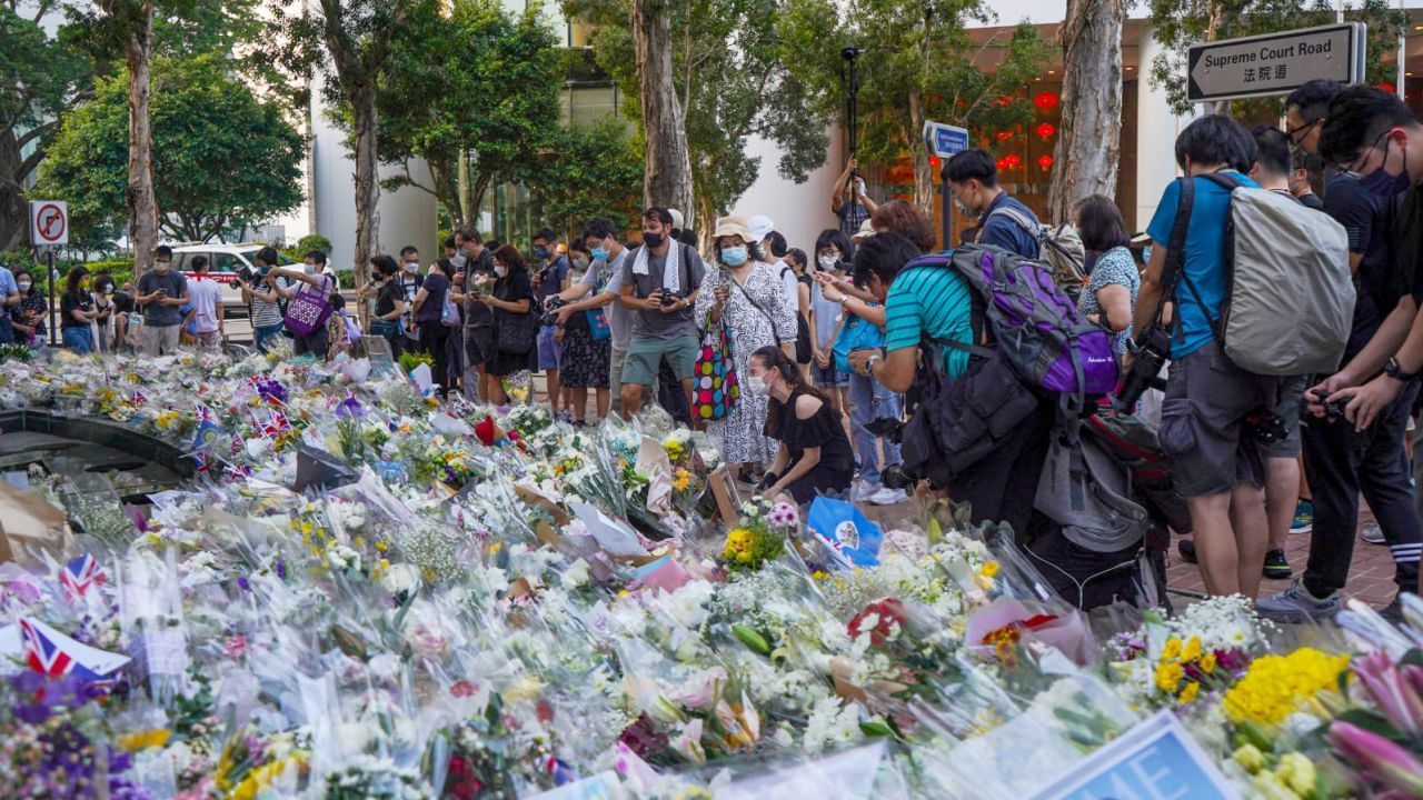 Uma mulher chorando se ajoelha para lamentar a morte da rainha Elizabeth II do lado de fora do consulado britânico em Hong Kong em 12 de setembro.