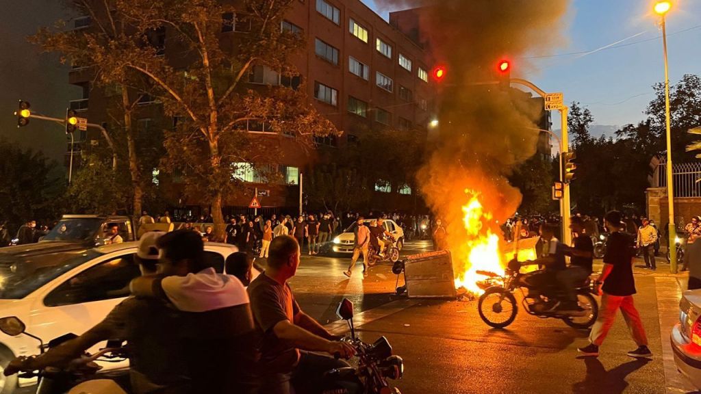 Manifestantes se reúnem em torno de uma barricada em chamas durante um protesto por Mahsa Amini em Teerã