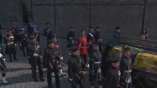 O rei Charles III (à esquerda, usando quepe com detalhe vermelho) acompanha cortejo do corpo da rainha Elizabeth II