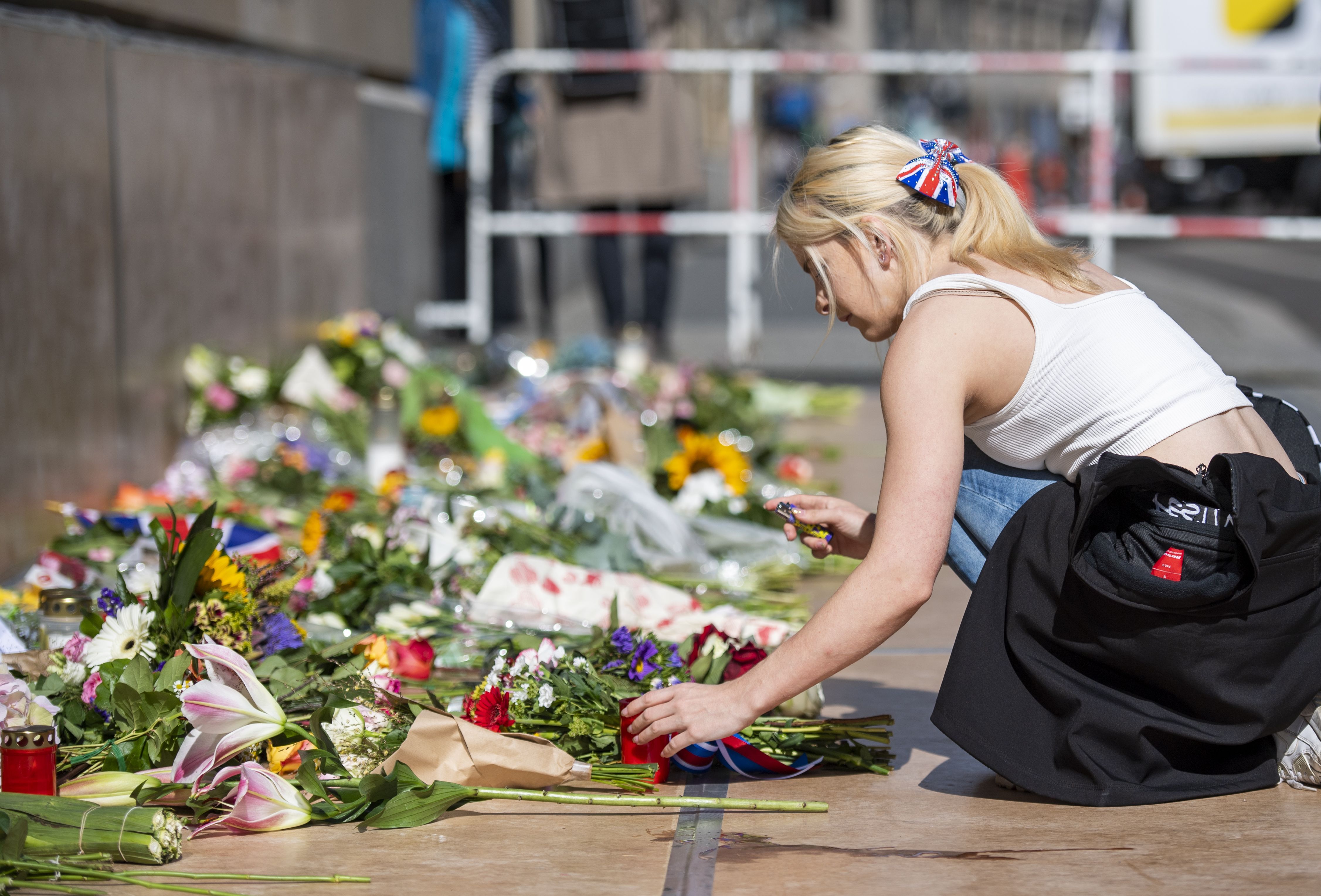 Mulher acende vela no lado de fora da Embaixada Britânica em Berlim após a morte da rainha Elizabeth II. / Christophe Gateau /picture aliança via Getty Images