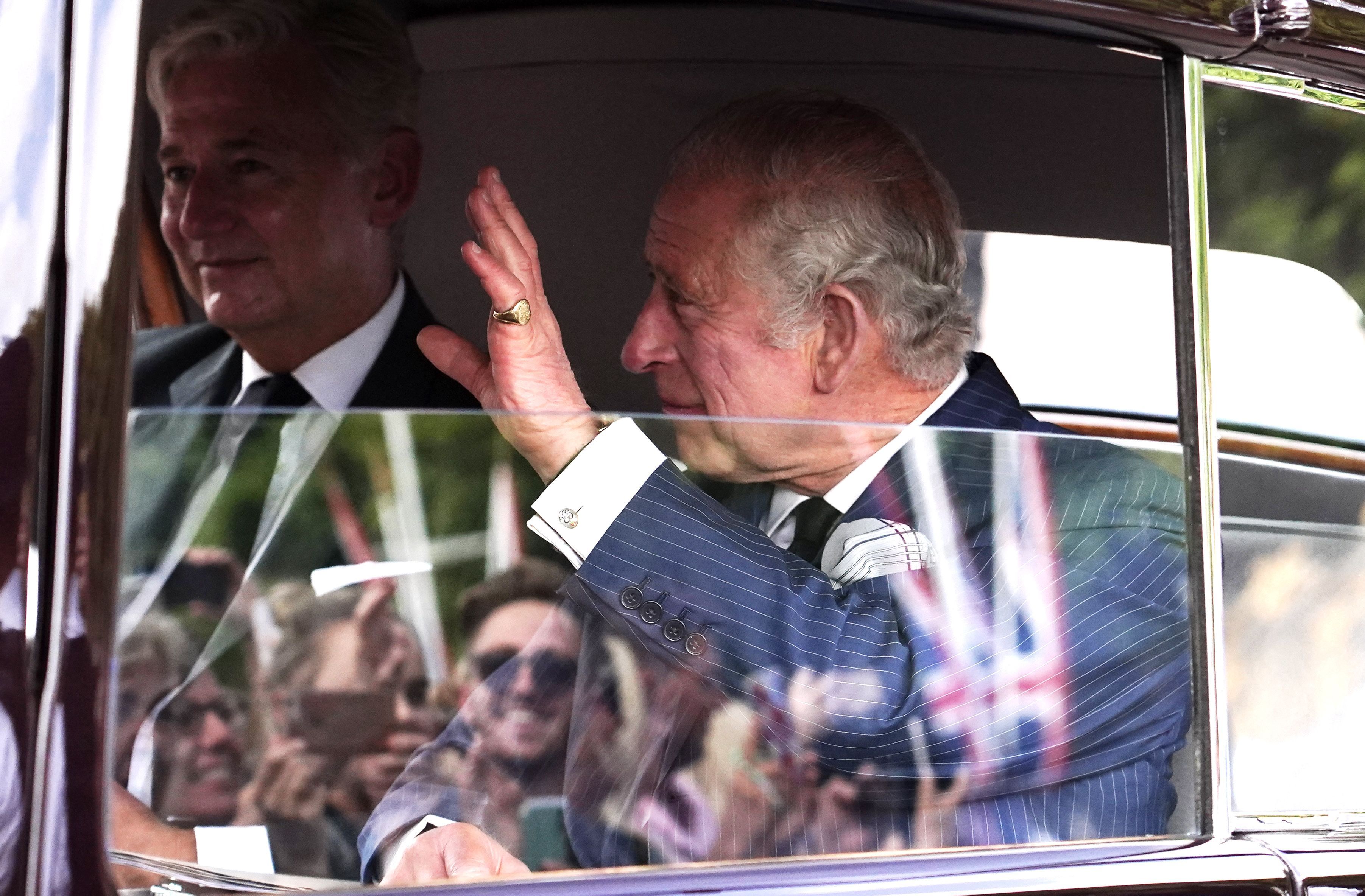 Rei Charles III acena ao público ao chegar no Palácio de Buckingham neste domingo, 11 de setembro de 2022. / Ian West/PA Images via Getty Images