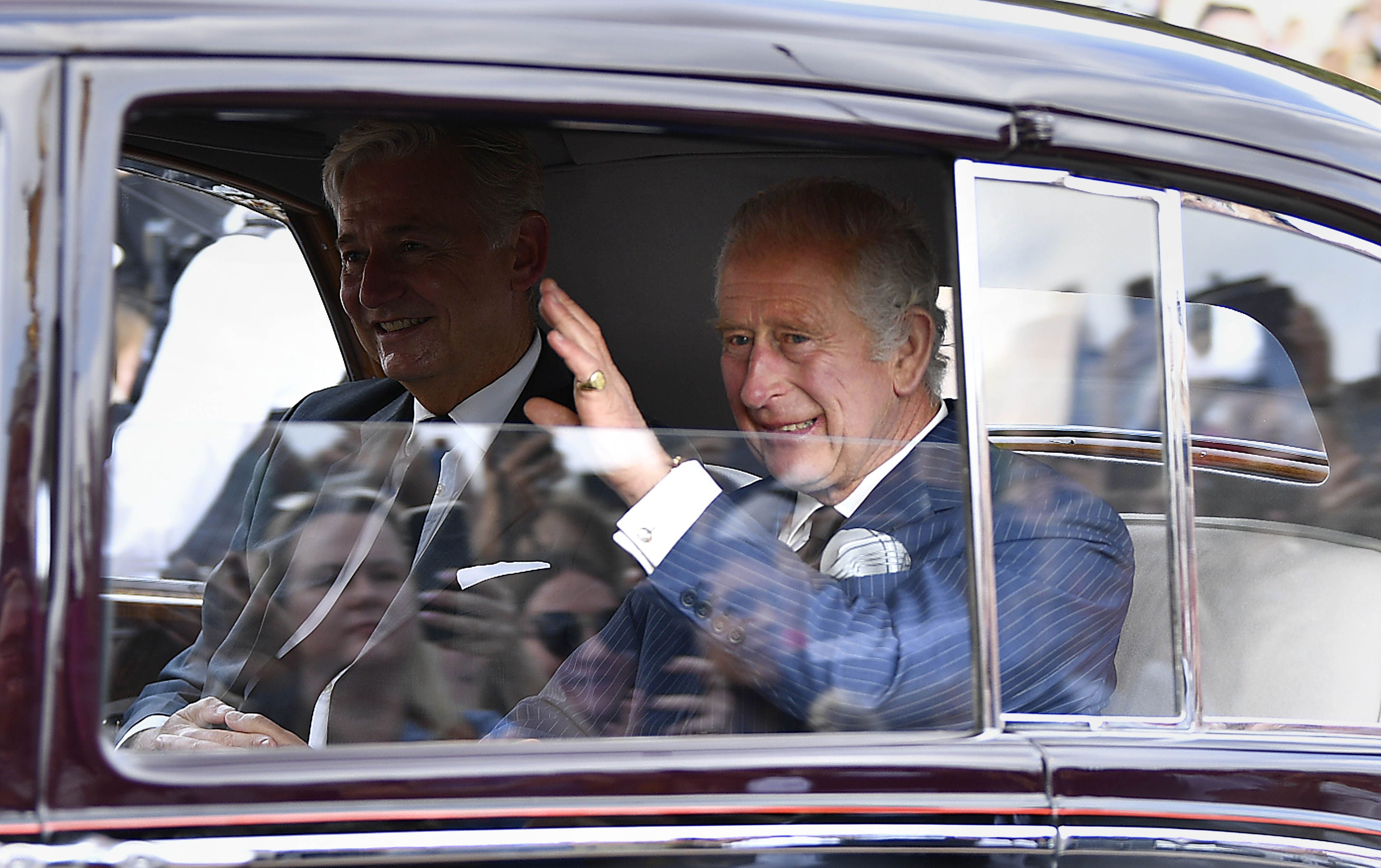 Rei Charles III acena ao público ao chegar no Palácio de Buckingham neste domingo, 11 de setembro de 2022.