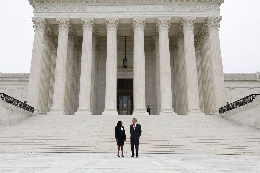A juíza associada da Suprema Corte dos EUA Ketanji Brown Jackson e o juiz John Roberts fazem uma pausa para fotos nos degraus da Suprema Corte após sua cerimônia de posse em 30 de setembro de 2022 em Washington. Anna Moneymaker/Getty Images