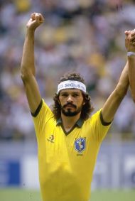 Sócrates ergue os braços após vitória em jogo da Copa do Mundo de 1986, no México. Naquele dia, em 1º de junho, a Seleção Brasileira derrotou a Espanha por 1 a 0.