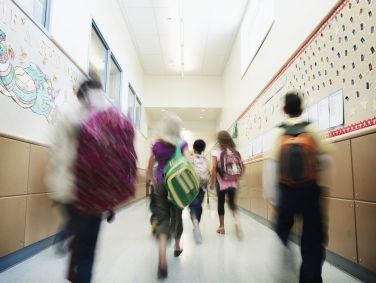 Jovens estudantes andando pelo corredor da escola