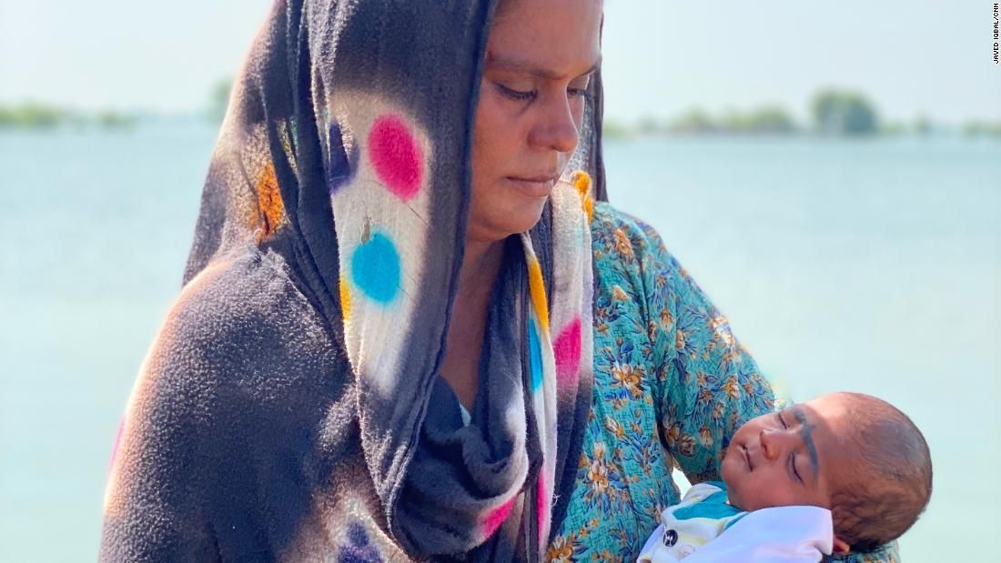 Kainat Solangi e seu bebê de 24 dias, Shumaila, cercados pelas águas da enchente, no Paquistão, em 5 de setembro de 2022 / Javed Iqbal / CNN