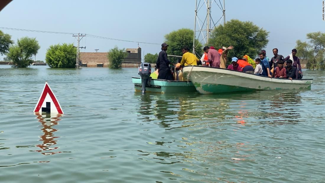 A água está tão alta que os moradores usam barcos para se locomover pela vila em busca de comida e outros suprimentos no Paquitão / Javed Iqbal / CNN