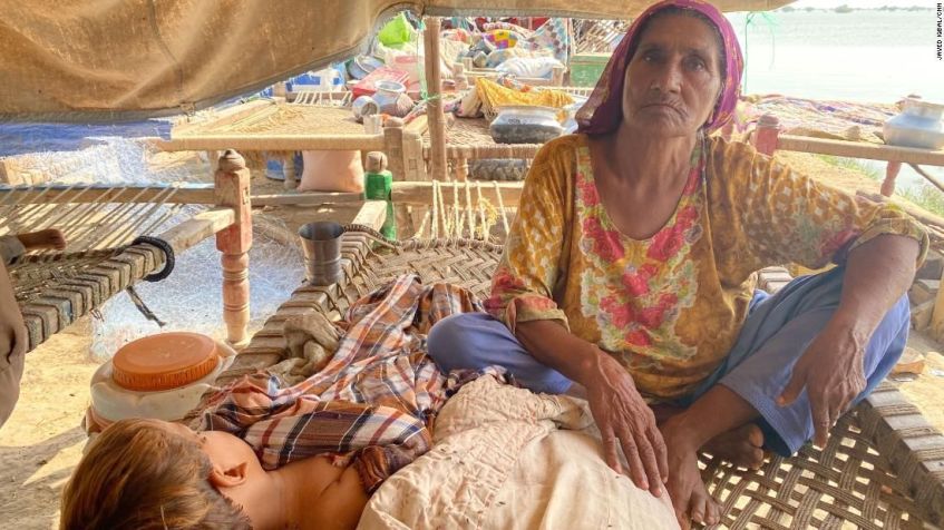 Mai Haleema cuida de um menino enquanto ele dorme, no Paquistão, em 5 de setembro de 2022 / Javed Iqbal / CNN