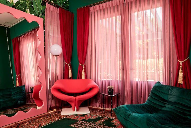 A "sala glam" tem um esquema de cores rosa e verde moderno/
