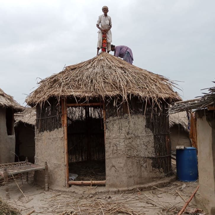 Os aldeões usam materiais como lama para fortalecer as paredes do abrigo de bambu. / Fundação Heritage do Paquistão