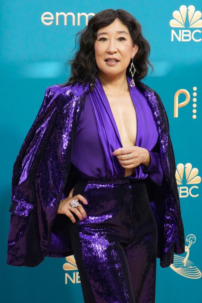 Sandra Oh chegou ao tapete vestindo macacão roxo com paetês e capa da Rodarte/ Getty Images