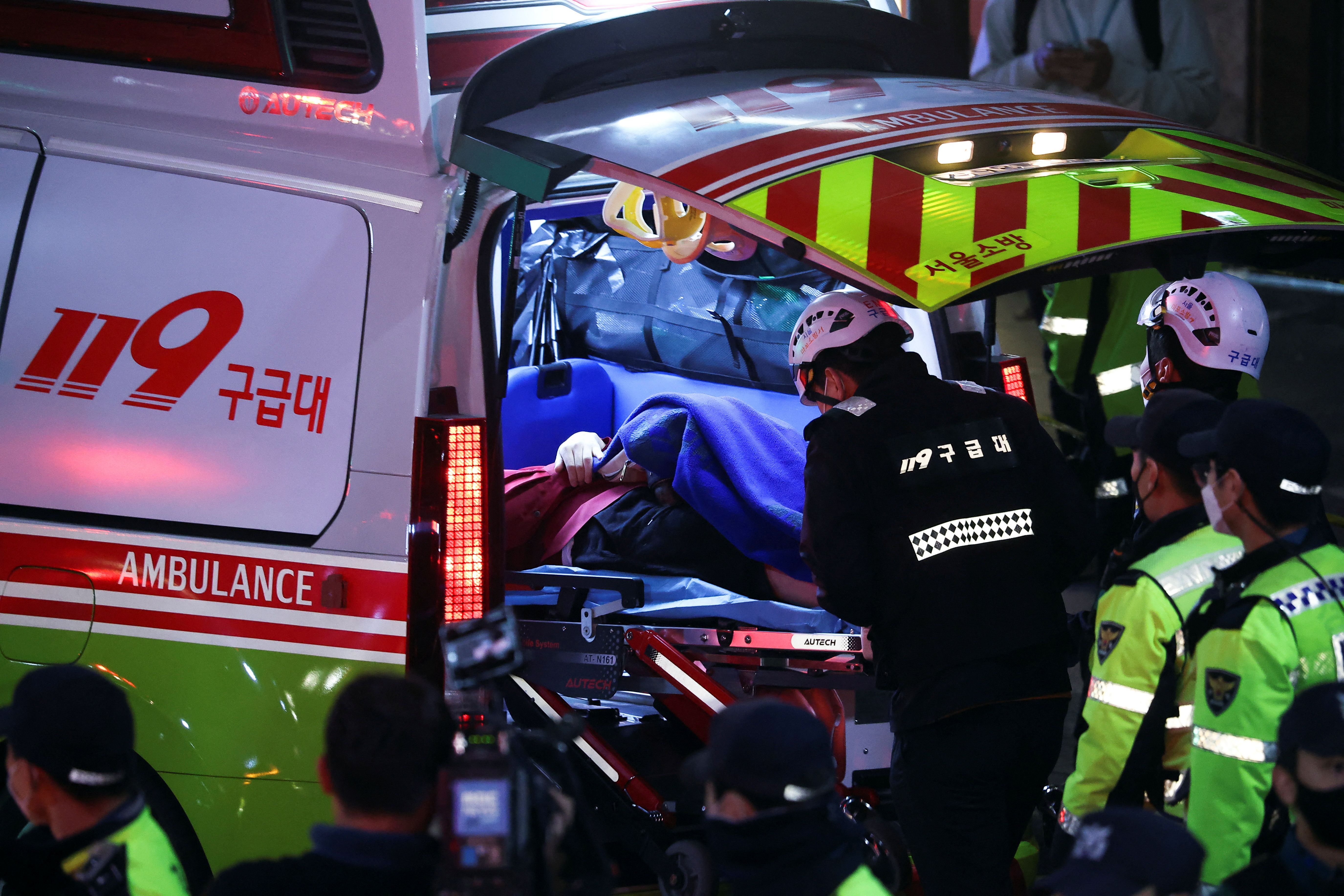 Pessoas sendo atendidas em ambulâncias após tumulto durante feste de Halloween; ao menos 150 pessoas morreram / Reuters/Kim Hong-ji