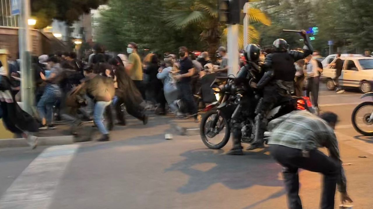 Um policial iraniano em uma moto levanta um cassetete para dispersar os manifestantes no mês passado. Stringer/AFP/Getty Images